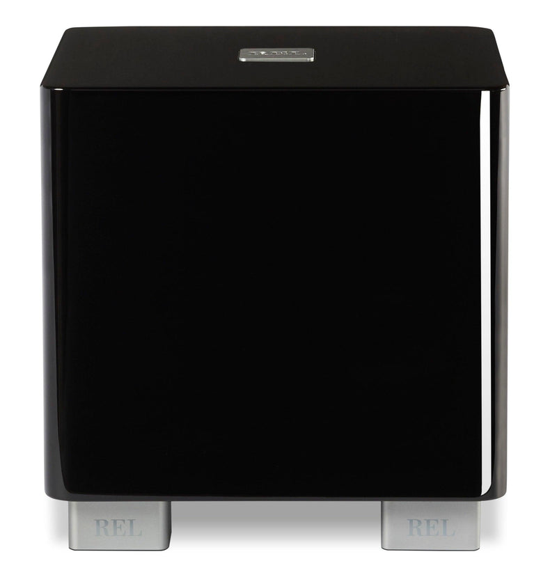 Subwoofer REL de alta fidelidad, acabado negro brillante con patas metálicas, ideal para sistemas de audio premium.